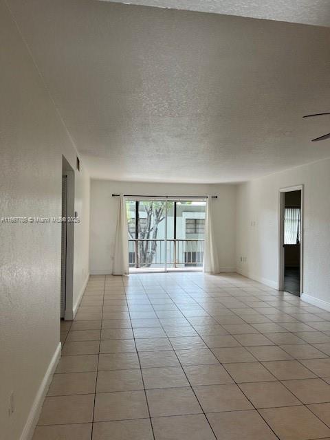 empty room with light tile patterned flooring and a textured ceiling