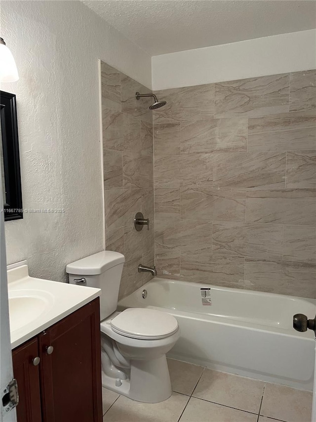 full bathroom featuring tiled shower / bath combo, vanity, a textured ceiling, tile patterned floors, and toilet