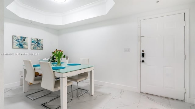 dining space with ornamental molding and a tray ceiling