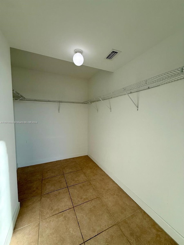 walk in closet with tile patterned floors