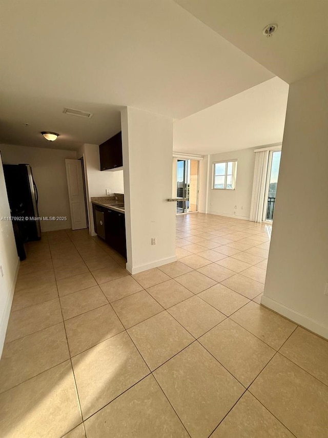 unfurnished room featuring light tile patterned floors and baseboards