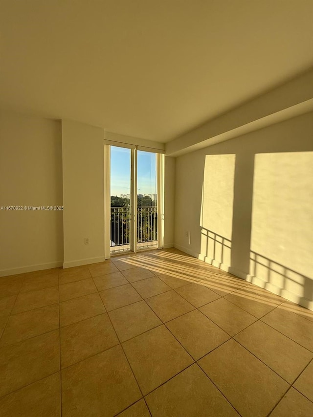 unfurnished room featuring tile patterned flooring and baseboards