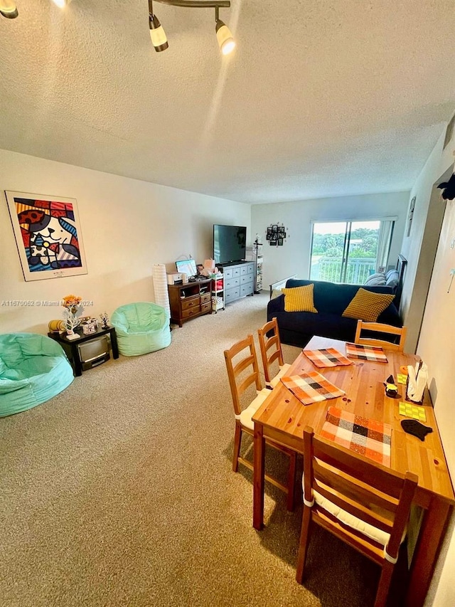 dining space with a textured ceiling and carpet flooring