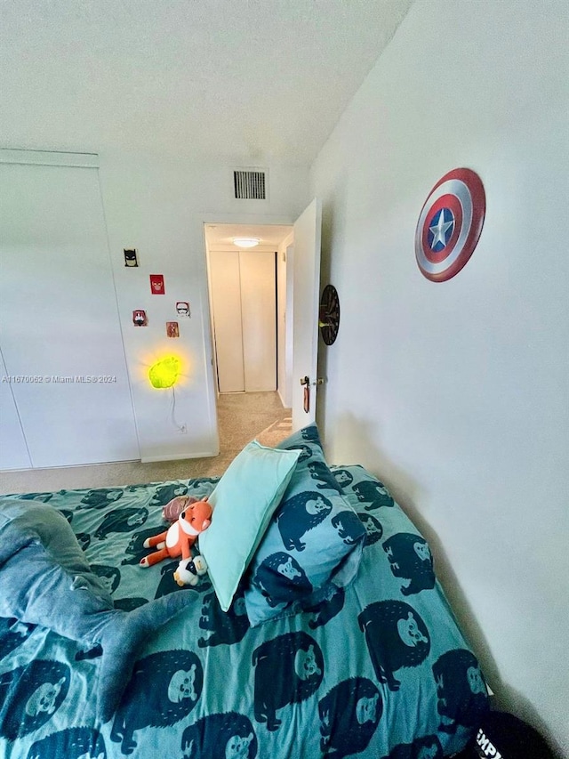 bedroom featuring a textured ceiling and carpet flooring