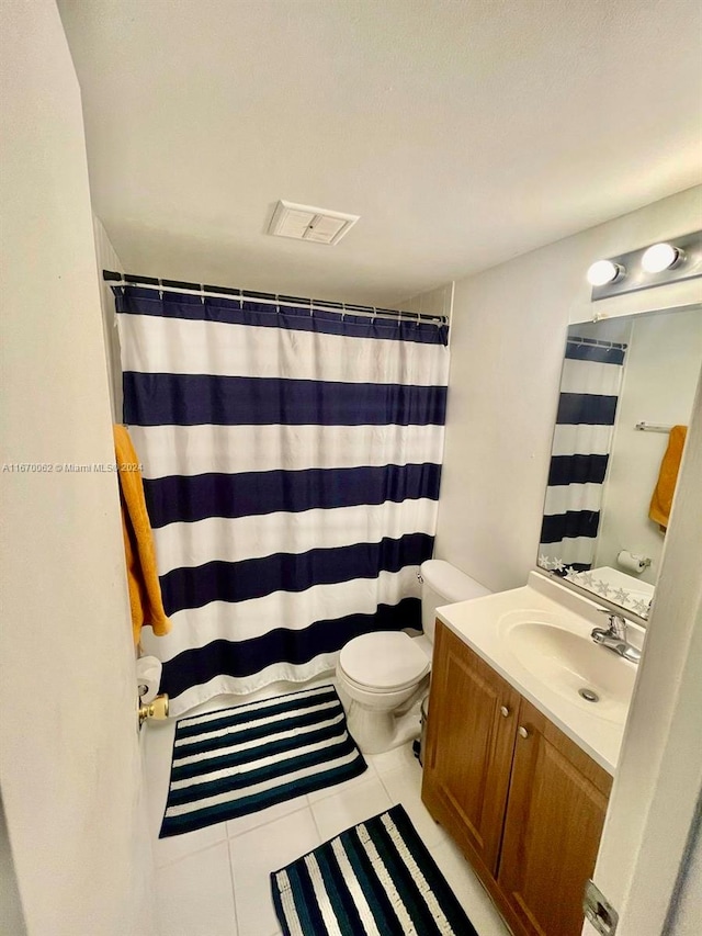 bathroom with a shower with shower curtain, tile patterned floors, vanity, and toilet