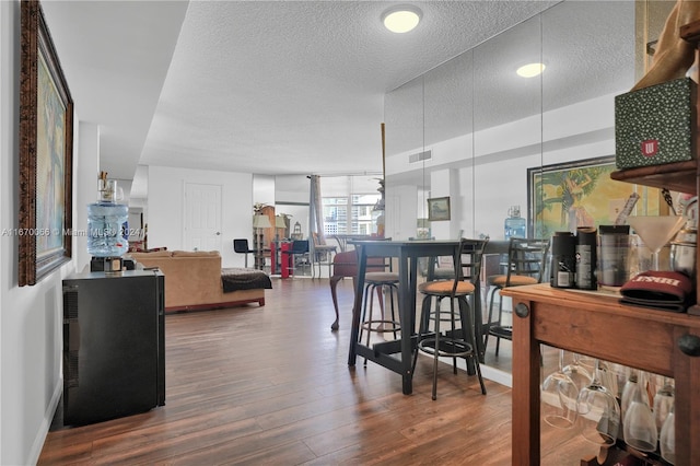 dining area with a textured ceiling and wood-type flooring