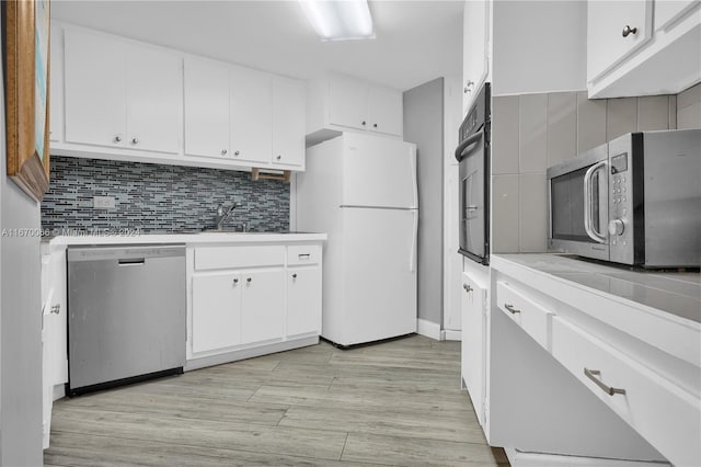 kitchen featuring appliances with stainless steel finishes, light hardwood / wood-style floors, tasteful backsplash, and white cabinets