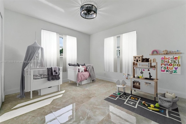 playroom featuring marble finish floor and baseboards