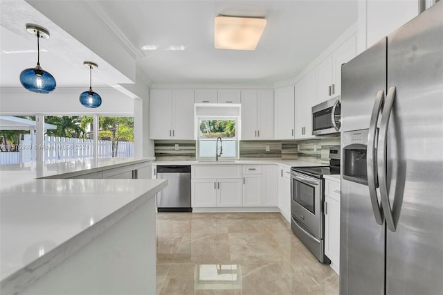 kitchen featuring stainless steel appliances, white cabinetry, sink, pendant lighting, and decorative backsplash