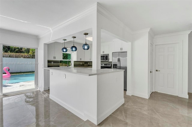 kitchen with ornamental molding, stainless steel appliances, decorative light fixtures, white cabinets, and a center island