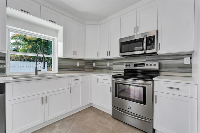 kitchen with tasteful backsplash, white cabinets, sink, and stainless steel appliances