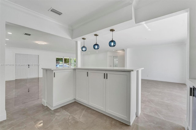 kitchen with pendant lighting, an island with sink, crown molding, and white cabinets