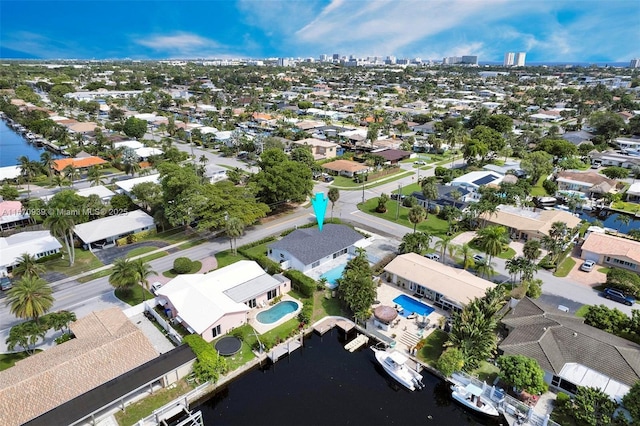 drone / aerial view featuring a city view, a residential view, and a water view
