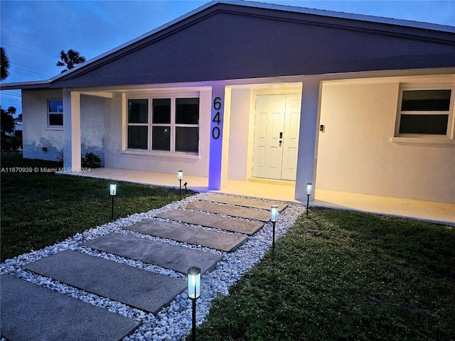 view of exterior entry with a yard