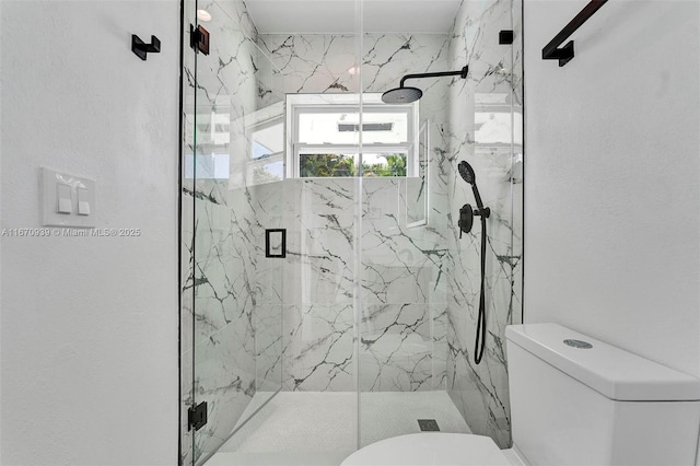 full bath with a marble finish shower and toilet