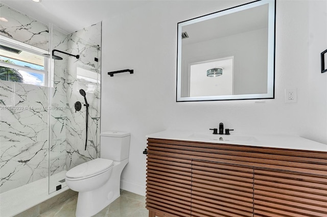 bathroom with tiled shower, tile patterned flooring, vanity, and toilet