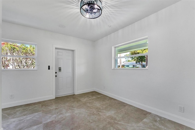 empty room featuring an inviting chandelier and plenty of natural light