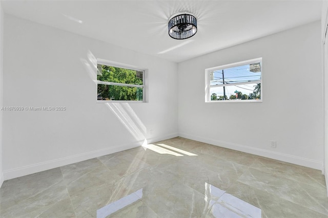 empty room featuring baseboards and a healthy amount of sunlight