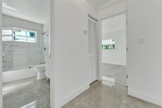 hallway featuring ornamental molding, baseboards, and plenty of natural light