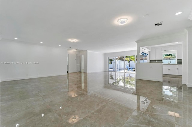 unfurnished room with ornamental molding, visible vents, recessed lighting, a sink, and baseboards