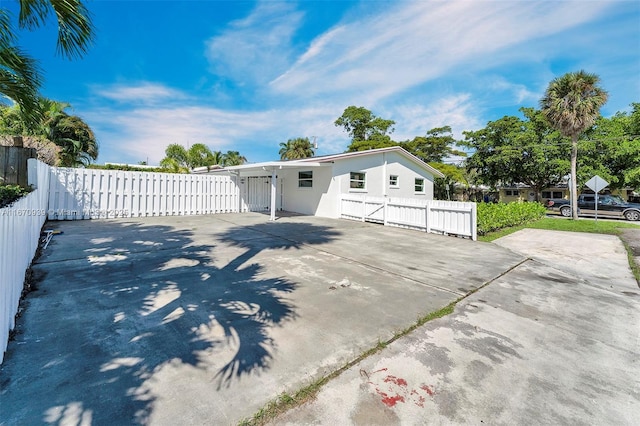 exterior space with concrete driveway, stucco siding, and fence