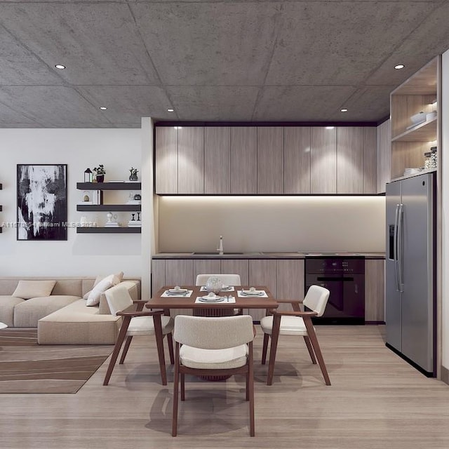 dining area with light wood-type flooring and sink