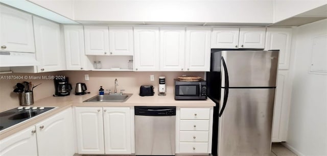 kitchen with stainless steel appliances, white cabinets, and exhaust hood