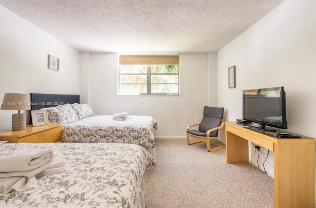 bedroom featuring a textured ceiling and light colored carpet