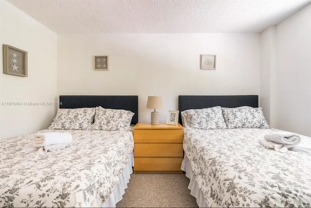 bedroom with a textured ceiling and light colored carpet