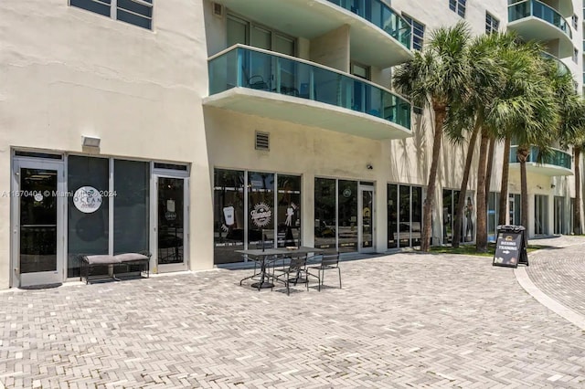 rear view of property featuring a patio, a balcony, and wine cooler