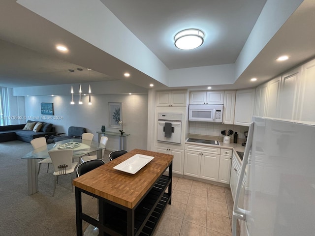 kitchen with backsplash, white appliances, white cabinetry, and light tile patterned floors