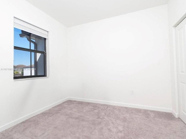 spare room featuring light colored carpet