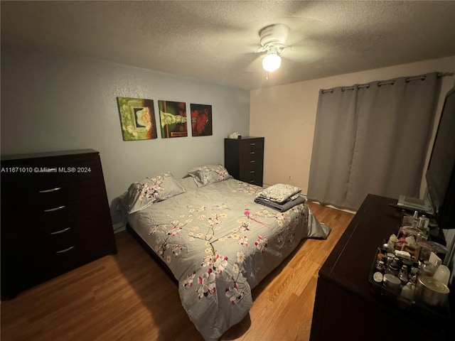 bedroom featuring a textured ceiling, ceiling fan, and hardwood / wood-style flooring