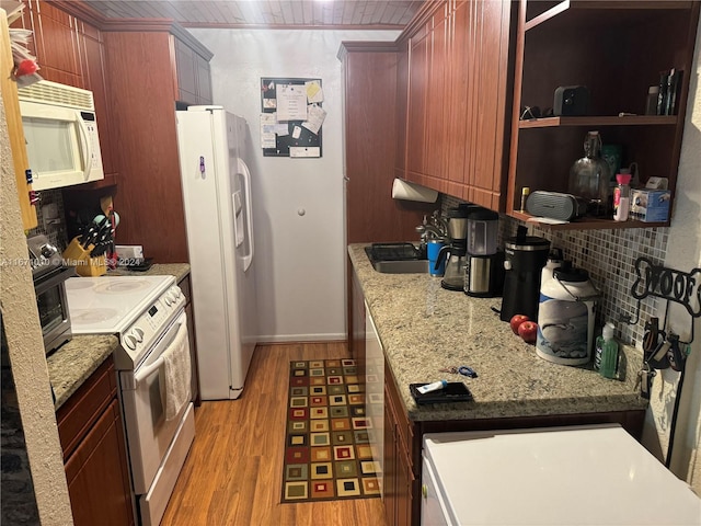 kitchen with light wood-type flooring, sink, decorative backsplash, white appliances, and light stone countertops