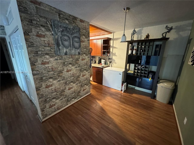 dining room featuring a textured ceiling and dark hardwood / wood-style flooring