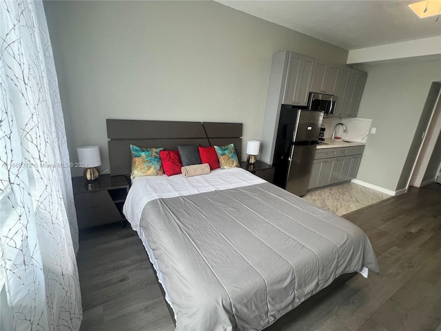 bedroom featuring stainless steel fridge, sink, and hardwood / wood-style flooring