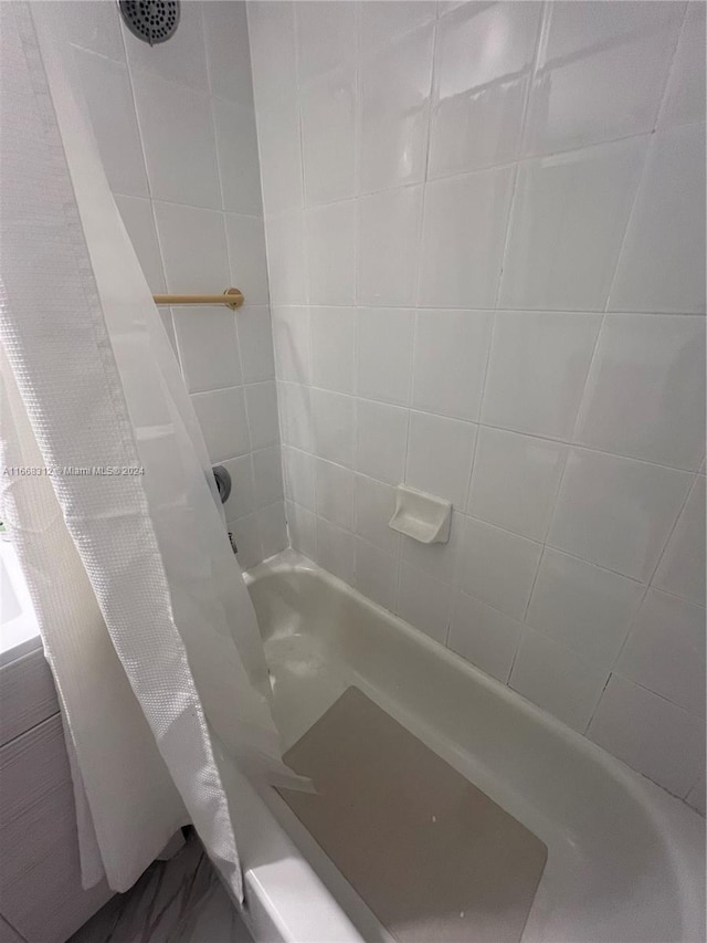 bathroom featuring shower / tub combo with curtain