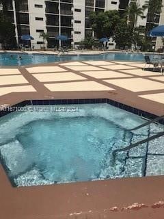 view of swimming pool featuring a hot tub