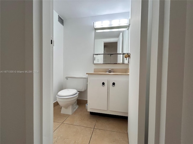 bathroom featuring toilet, vanity, and tile patterned floors