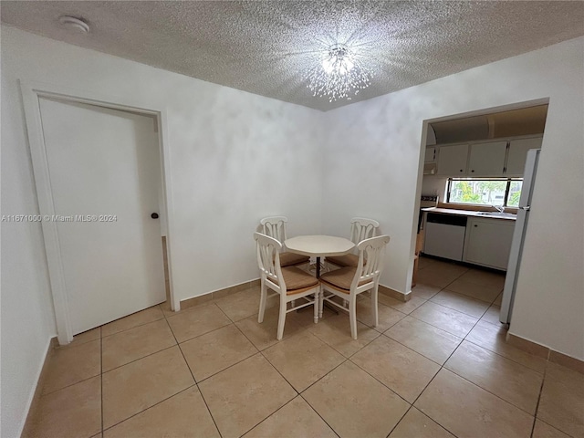 unfurnished dining area featuring light tile patterned flooring, a textured ceiling, and an inviting chandelier