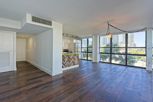 unfurnished living room with expansive windows, dark hardwood / wood-style flooring, and rail lighting