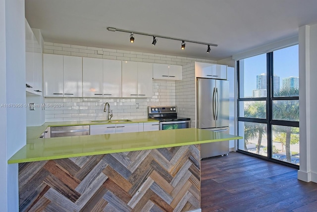 kitchen with white cabinets, appliances with stainless steel finishes, sink, and kitchen peninsula