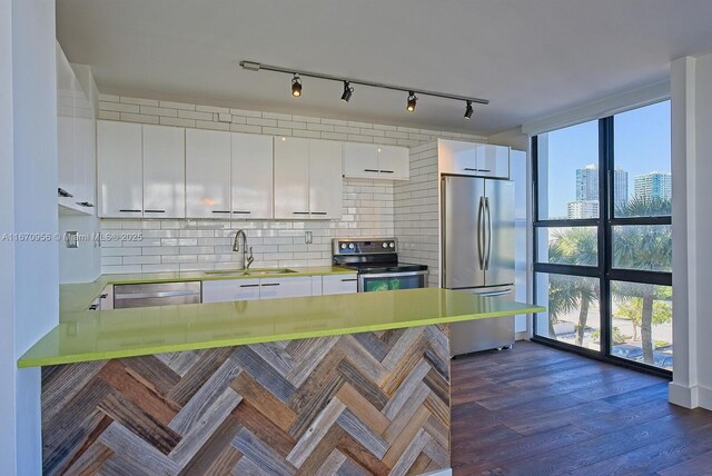 600 NE 36th St Unit 423, Miami, FL 33137 - kitchen featuring stainless steel appliances, a sink, tasteful backsplash, white cabinets, and light countertops