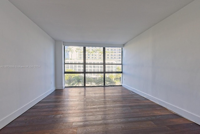 unfurnished room featuring floor to ceiling windows and dark hardwood / wood-style floors