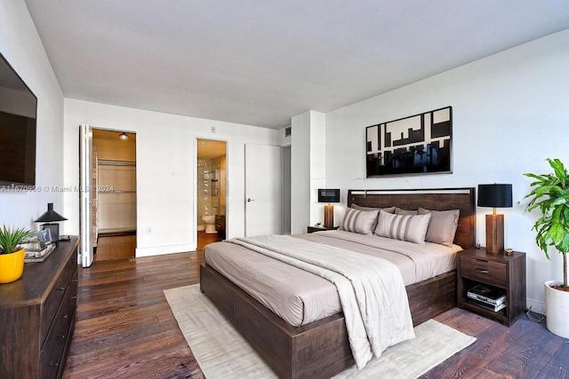 bedroom featuring connected bathroom, dark hardwood / wood-style floors, and a spacious closet