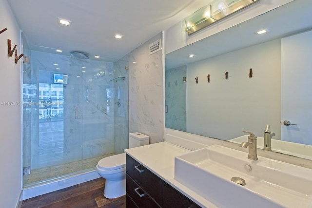 bathroom with a shower with door, vanity, toilet, and hardwood / wood-style flooring