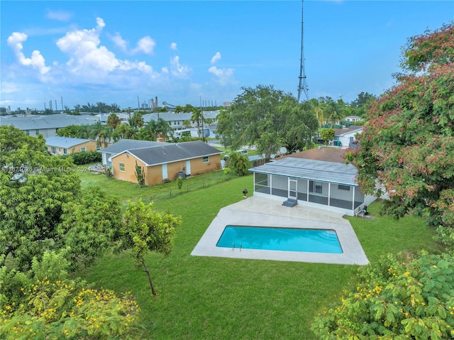 view of swimming pool featuring a sunroom, a yard, and a patio