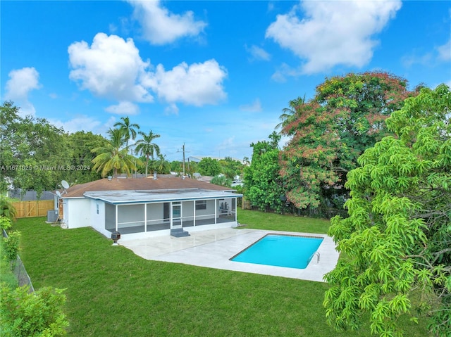 back of house with a lawn, a fenced in pool, a sunroom, and a patio area