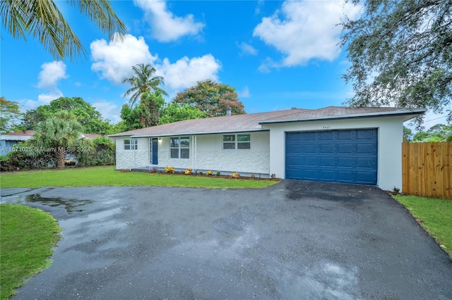 single story home featuring a front yard and a garage