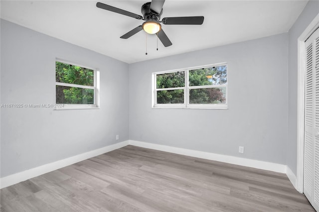 unfurnished bedroom featuring ceiling fan, a closet, and light hardwood / wood-style flooring